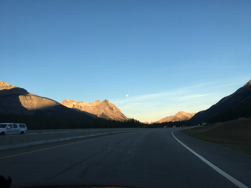 The moon setting over the Rockies in the sunrise